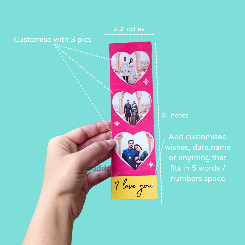 Hand holding a pink photo strip with heart-shaped cutouts and text on a teal background