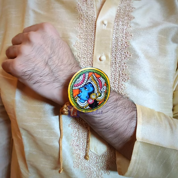 A man wearing the handcrafted Krishna synthetic leather rakhi styled as a divine lapel brooch on festive ethnic wear.