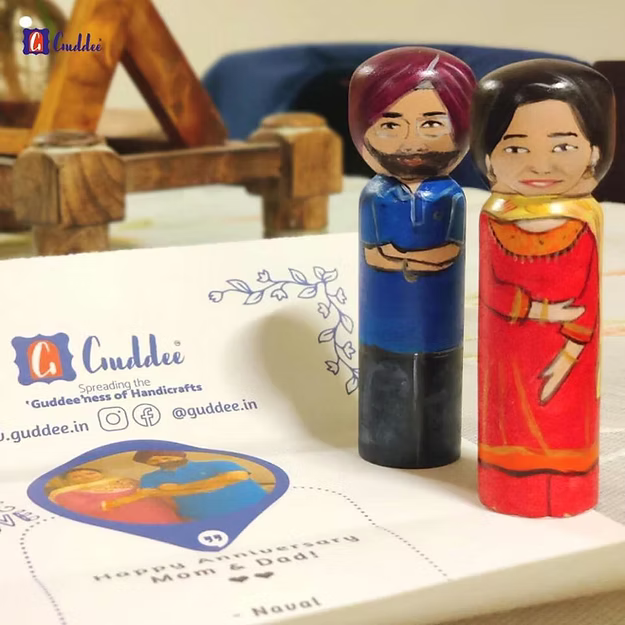 A handcrafted medium custom wooden couple doll set displayed as unique milestone anniversary decor on a living room shelf.