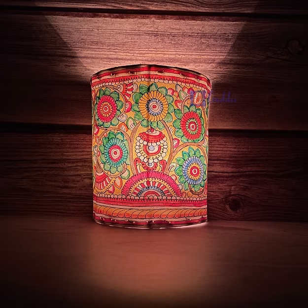 A lit synthetic leather floral tea light holder sitting as a modern decorative centerpiece table runner accent.