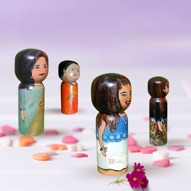 Four custom wooden peg dolls of varying heights hand-painted by regional artisans to match a 4-member family portrait.