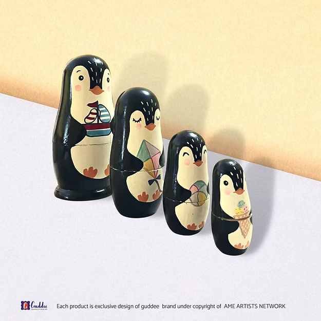Set of 4 penguin nesting dolls showing the hand-painted pine wood character details in sequence by Guddee.