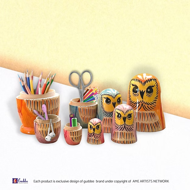 Handcrafted owl nesting boxes opened on a desk to reveal house keys, coins, and AirPods stored safely inside.