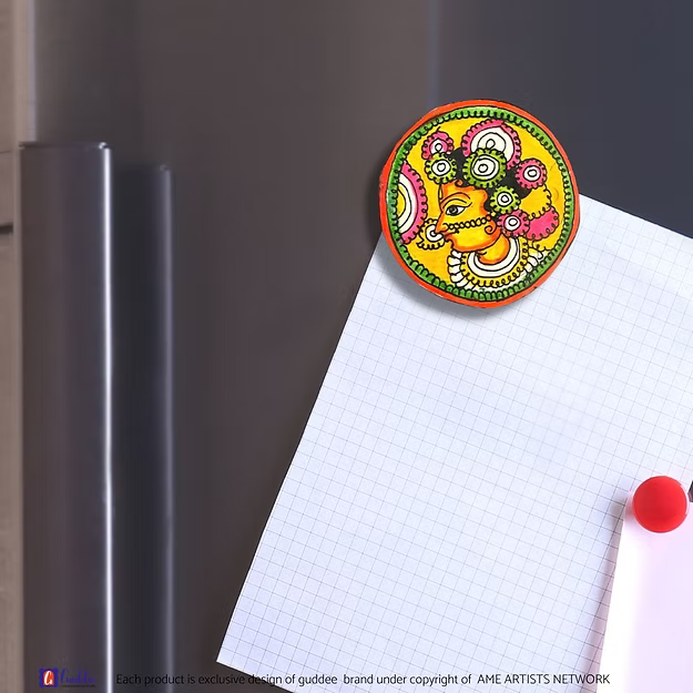 An authentic Radha faux leather magnet holding a reminder note on a modern steel kitchen refrigerator door panel.