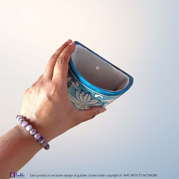 Aasmani blue blue pottery wall planter pot showing the vibrant sky-blue hand-painted floral motifs by Guddee.
