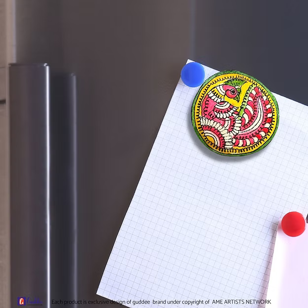An authentic Peacock faux leather magnet holding a reminder note on a modern steel kitchen refrigerator door panel.