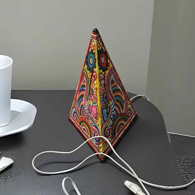 Close-up of the detailed peacock cutout silhouette on Guddee's heat-resistant triangle faux leather candle stand lamp.