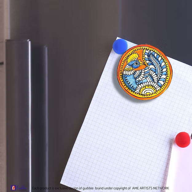 An authentic Blue Peacock faux leather magnet holding a reminder note on a modern steel kitchen refrigerator door panel.