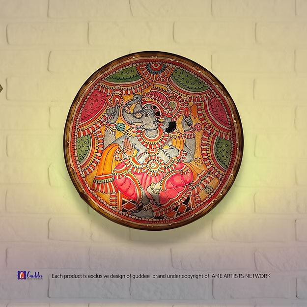 A lit translucent Tholu Bommalata leather Ganesha sconce projecting a glowing, multi-colored folk pattern on a hallway wall.