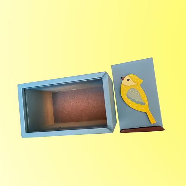 A compact handcrafted mini birdie box sliding open smoothly to reveal jewelry and office accessories on a modern desk setup.