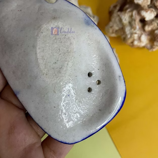 Close-up of the smooth light blue ceramic glaze finish on an artisan-thrown clay incense stick holder.