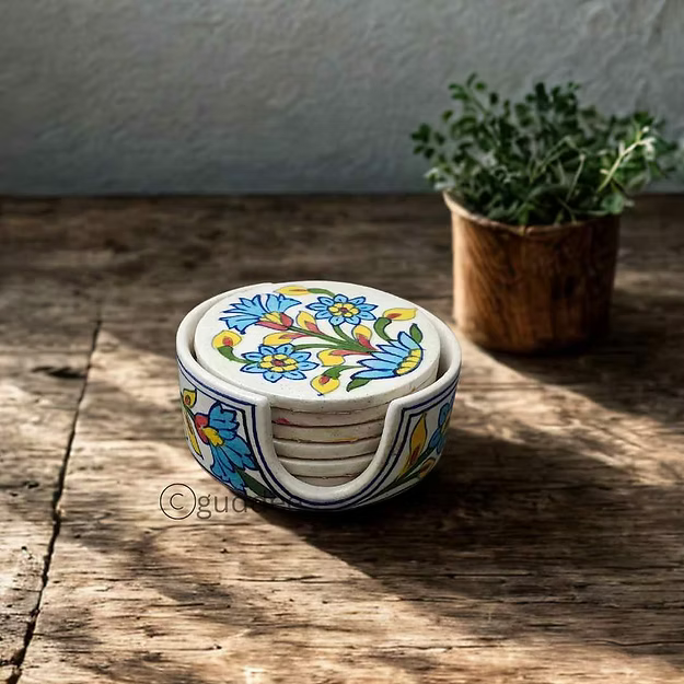 Set of 5 white handcrafted Jaipur blue pottery drink coasters stacked neatly inside their matching ceramic storage holder.