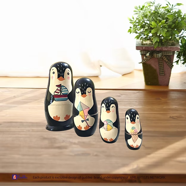Close-up of the natural pine wood grain and glossy hand-painted penguin face detailing on Guddee's stacking doll shell.