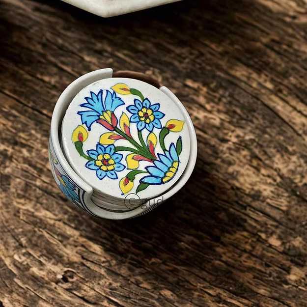 Set of 5 white handcrafted Jaipur blue pottery drink coasters stacked neatly inside their matching ceramic storage holder.