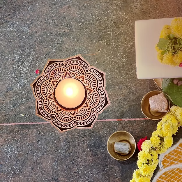 Close-up of the rich natural sheesham wood grain and intricate mandala silhouette cutouts on Guddee's candle stand.