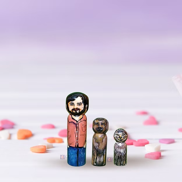 Three custom wooden peg dolls of varying heights hand-painted by regional artisans to match a 3-member family portrait.