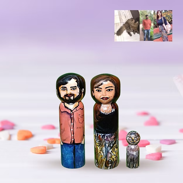 Three custom wooden peg dolls of varying heights hand-painted by regional artisans to match a 3-member family portrait.