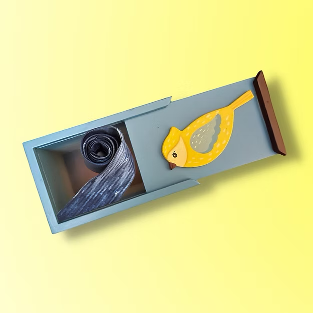 A compact handcrafted mini birdie box sliding open smoothly to reveal jewelry and office accessories on a modern desk setup.
