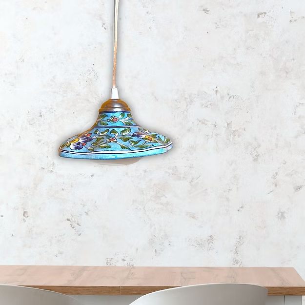 A premium handcrafted ceramic blue pottery lamp styled as a luxury hanging wall sconce on a modern living room wall.