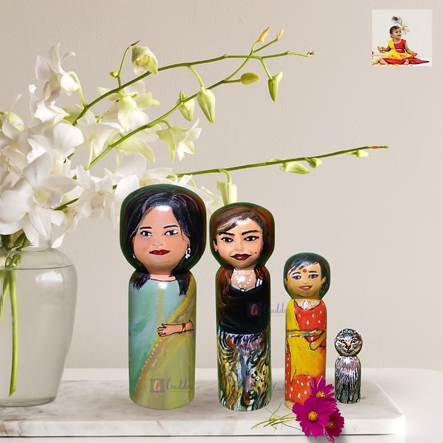 Four custom wooden peg dolls of varying heights hand-painted by regional artisans to match a 4-member family portrait.