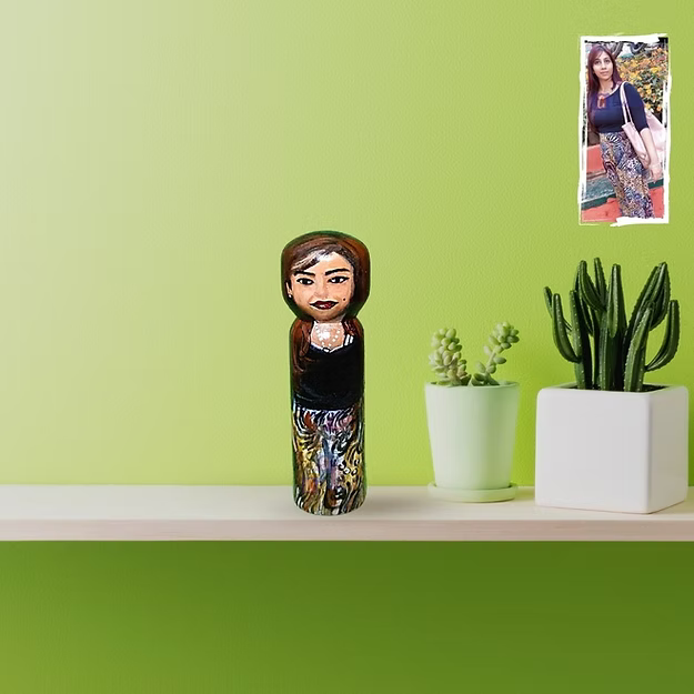 A beautifully wrapped custom medium 3D female lookalike caricature doll displayed on a shelf as a sentimental gift.