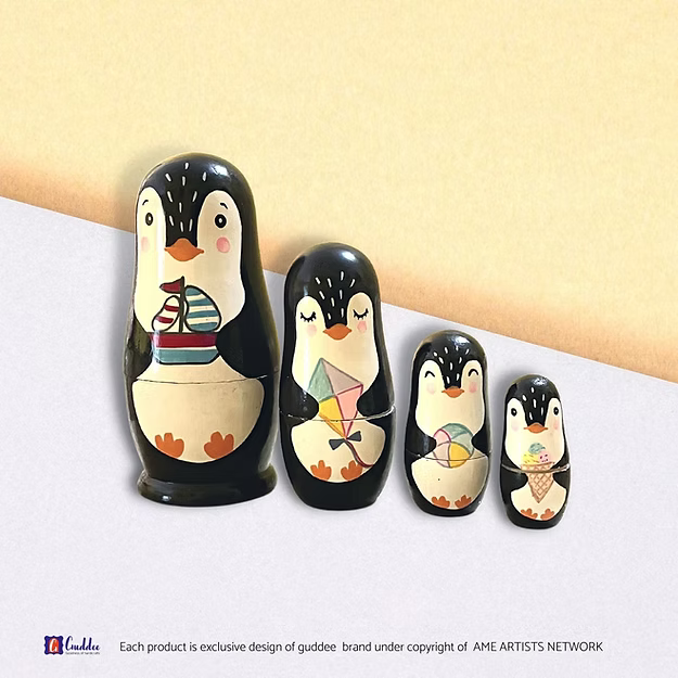 Set of 4 penguin nesting dolls showing the hand-painted pine wood character details in sequence by Guddee.