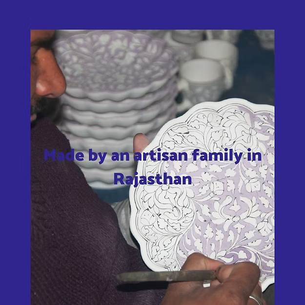 Person holding a piece of intricately designed pottery with text about artisan family from Rajasthan.