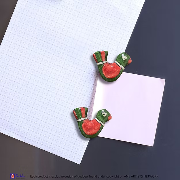 A handcrafted traditional Red Green bird couple magnet holding a memo securely on a kitchen refrigerator door.