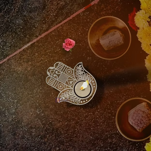 An illuminated handcrafted Sheesham wood Hamsa hand candle holder diffusing a warm protective flame on a yoga altar.