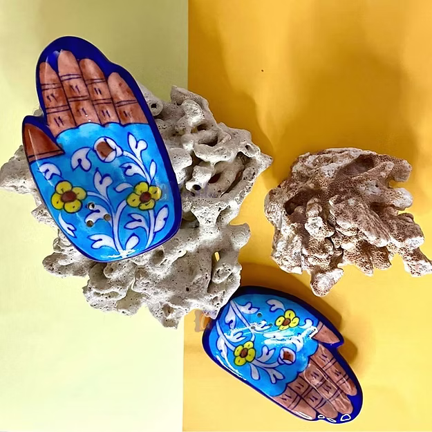 Light blue handcrafted pottery agarbatti incense stick holder with an integrated ceramic ash catching basin.