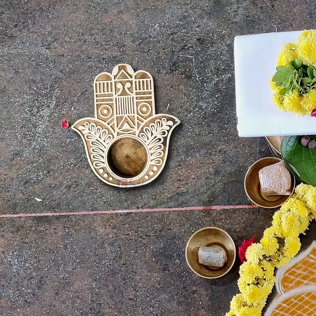 Hamsa Sheesham wood tea light holder showing the detailed hand-carved open palm details and finish by Guddee.
