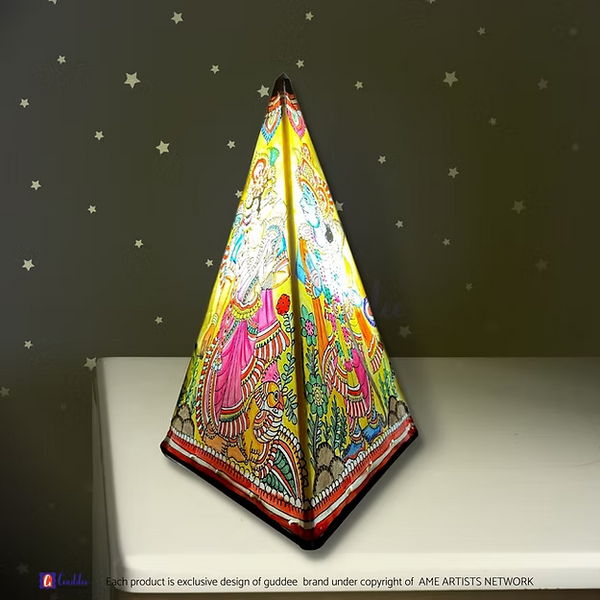 A lit triangular synthetic leather Ram Sita silhouette lamp casting a warm ambient glow as a decorative prayer room centerpiece.