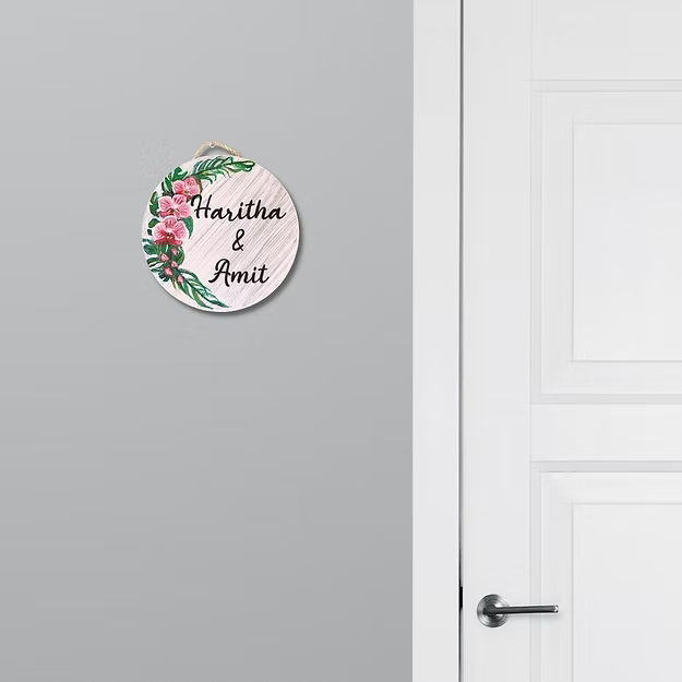 Personalised orchid floral name plate featuring a custom family name mounted next to a modern home entrance door.