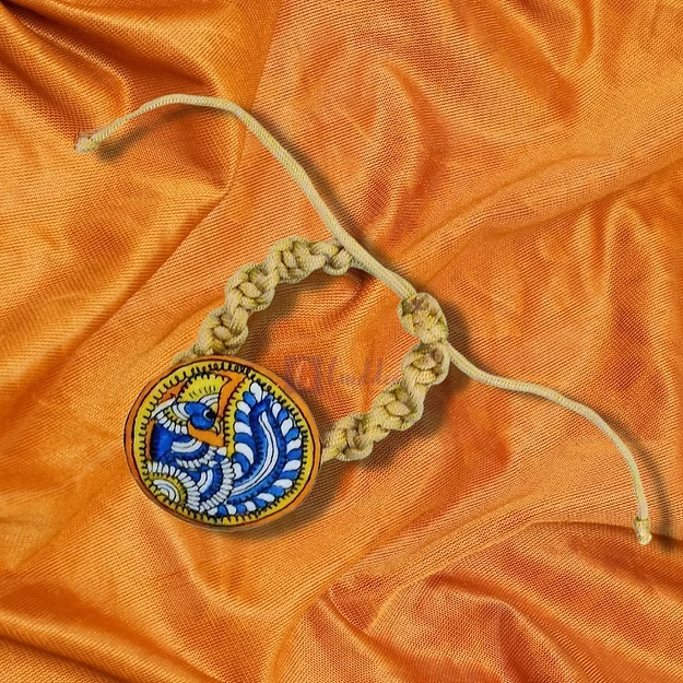 Close-up of the detailed artisan cutting and stitching on the premium eco-friendly synthetic leather peacock rakhi.