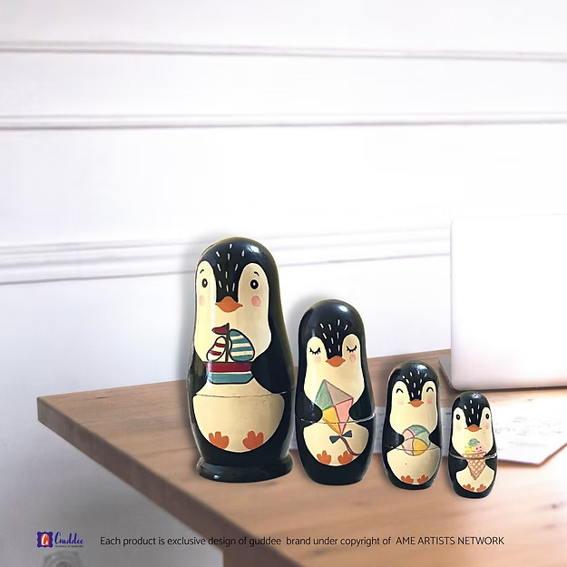 Set of 4 penguin nesting dolls showing the hand-painted pine wood character details in sequence by Guddee.