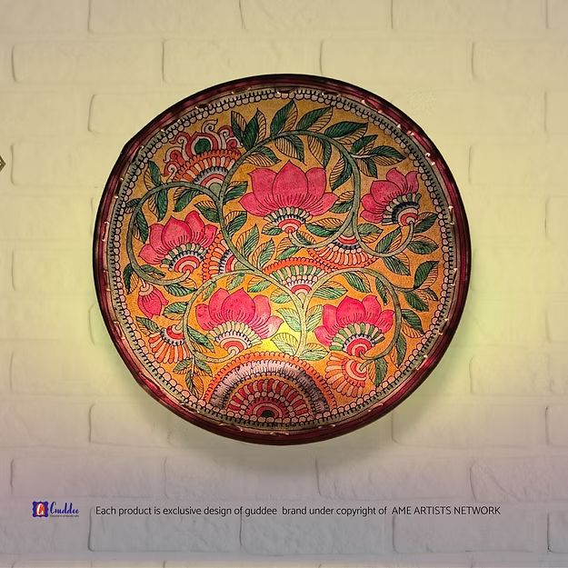 A lit translucent Tholu Bommalata leather Lotus sconce projecting a glowing, multi-colored folk pattern on a hallway wall.