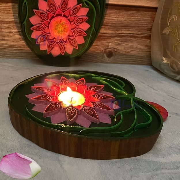 A lit rosewood lotus tealight holder sitting as a warm decorative centerpiece table runner accent on a wooden dining table.