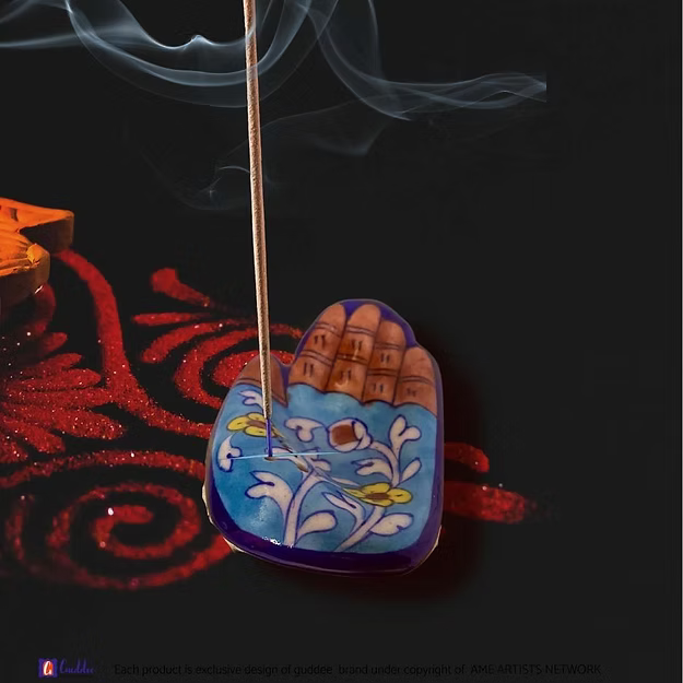 Light blue handcrafted pottery agarbatti incense stick holder with an integrated ceramic ash catching basin.