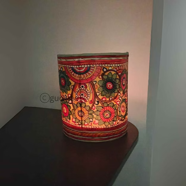 A lit synthetic leather floral tea light holder sitting as a modern decorative centerpiece table runner accent.