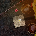 An illuminated handcrafted Sheesham wood square mandala candle holder diffusing a warm amber flame on a modern home mantle.