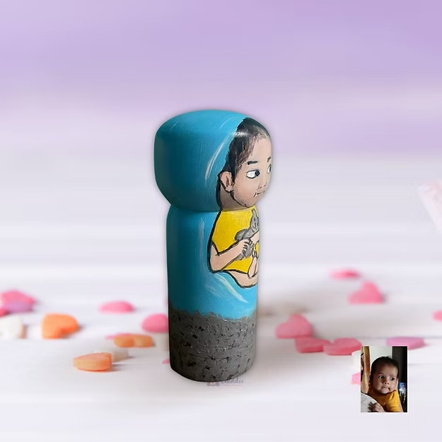 A personalized handcrafted wooden infant portrait doll standing as a sentimental decor piece on a baby nursery shelf.